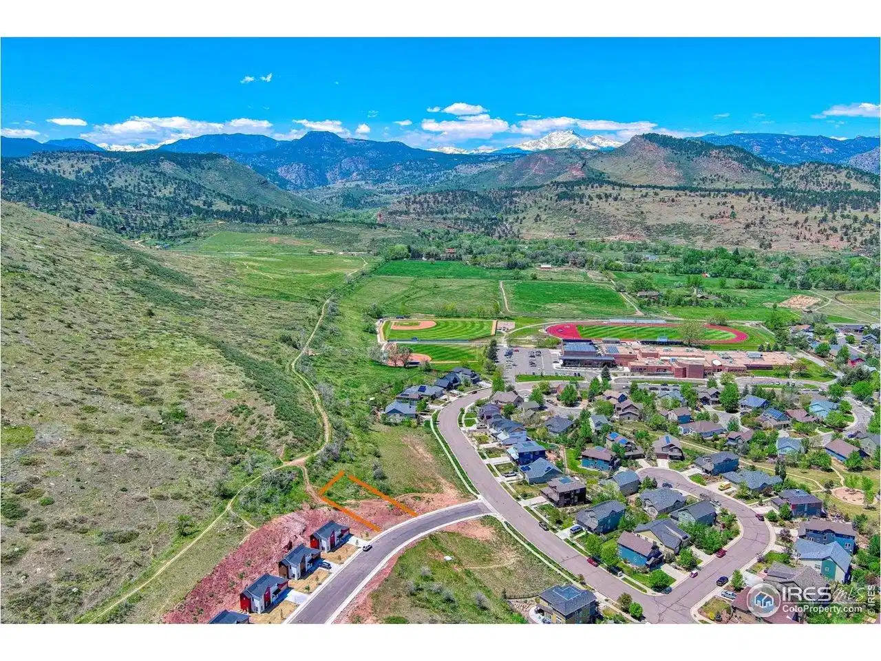 Image 1: Drone shot with view of neighborhood and back range. Lot Location outlined in Orange Image 1: Drone shot with view of neighborhood and back range. Lot Location outlined in Orange