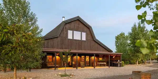 Image 2: Natural rough-cut wood siding, expansive windows and a deep covered porch give the residence a distinctive ranch-inspired presence. Image 2: Natural rough-cut wood siding, expansive windows and a deep covered porch give the residence a distinctive ranch-inspired presence.