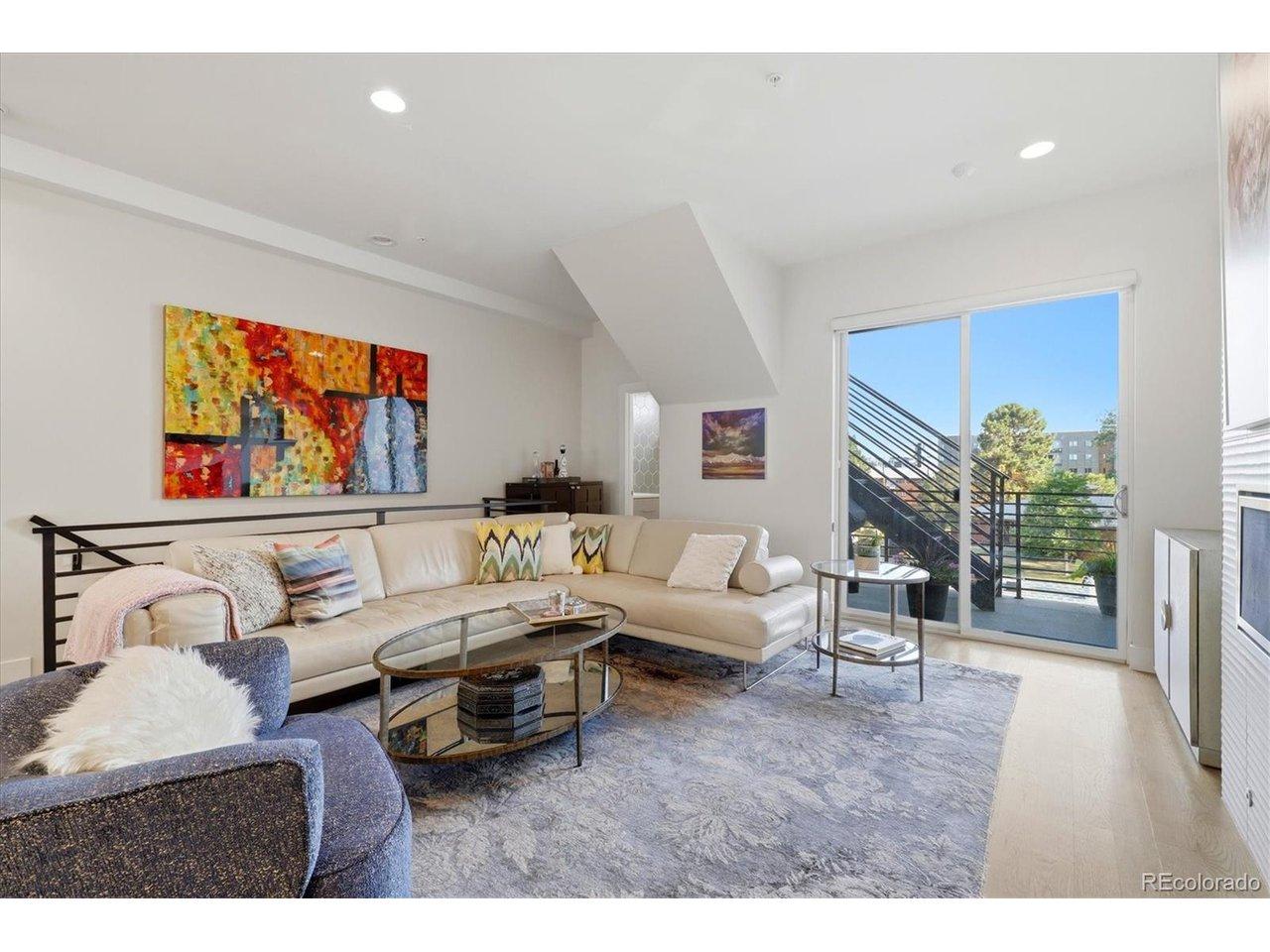 Image 4: The spacious living room opens to a private balcony and stairs leading to the rooftop deck.