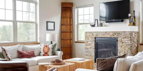 Image 3: Cozy gas fireplace with stone surround serves as the focal point of the living space