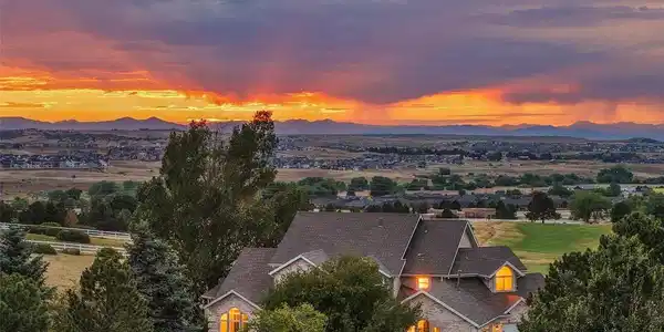 Image 2: An elevated twilight view captures the home's impressive arrival, mature landscaping and sweeping Front Range sunset backdrop. Image 2: An elevated twilight view captures the home's impressive arrival, mature landscaping and sweeping Front Range sunset backdrop.