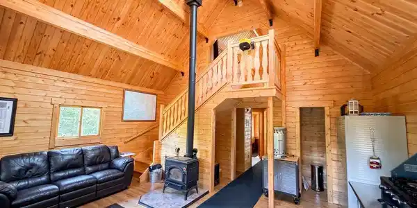 Image 4: The great room invites you in to a fantastic space with vaulted ceilings and useful amenities. AI Enhanced images.