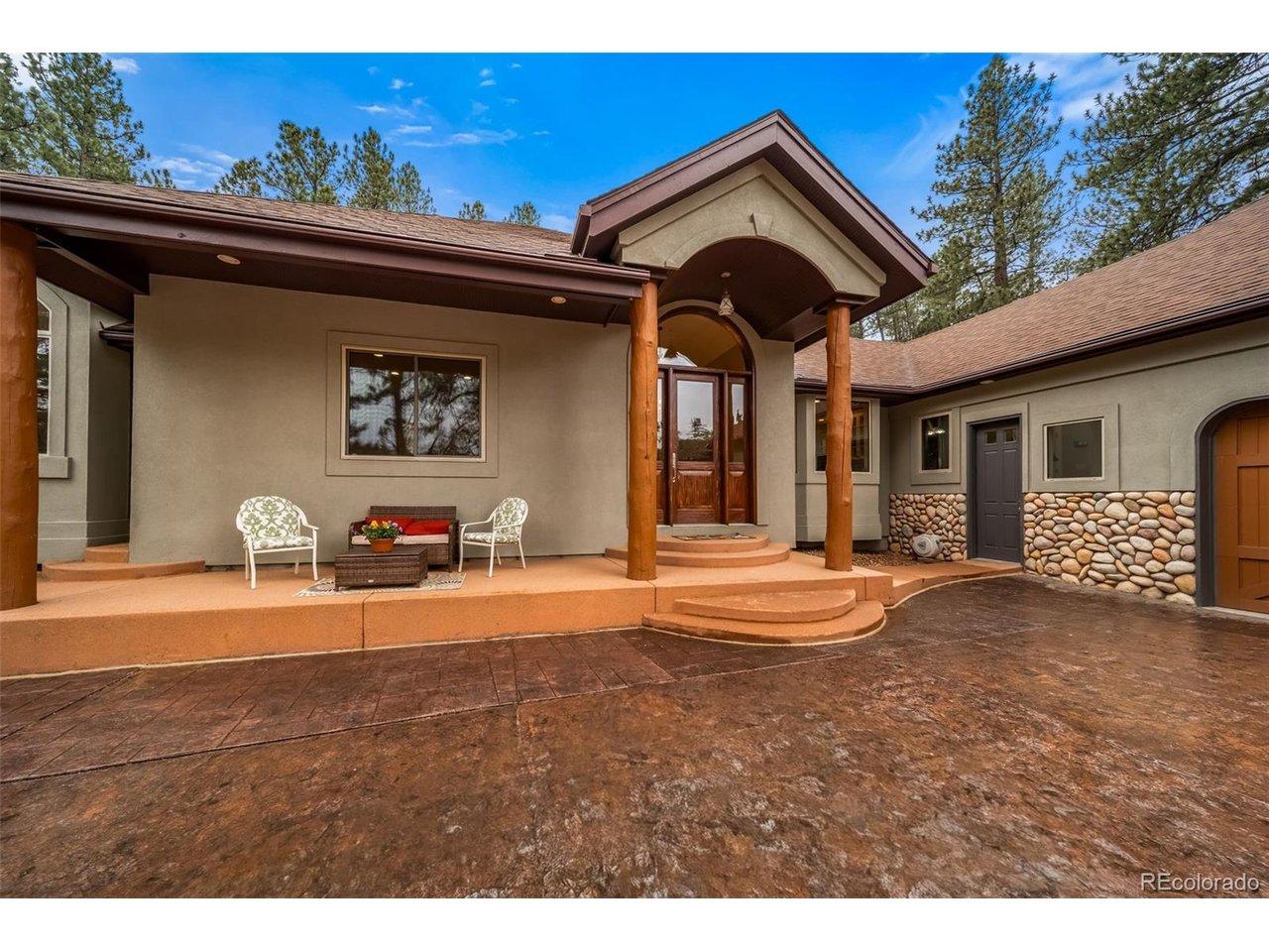 Image 3: covered front porch with garage entrance, front door, and rustic log pillars. Stone carried through into interior. Image 3: covered front porch with garage entrance, front door, and rustic log pillars. Stone carried through into interior.