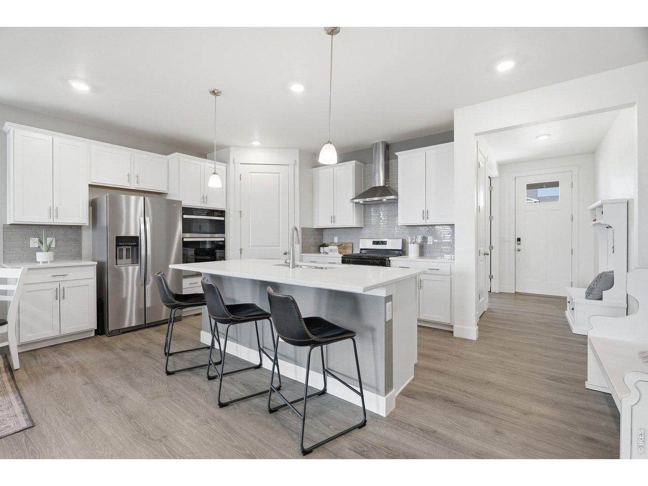 Image 3: The large chef's kitchen features quartz counters with plenty of natural light and prep space. Image 3: The large chef's kitchen features quartz counters with plenty of natural light and prep space.