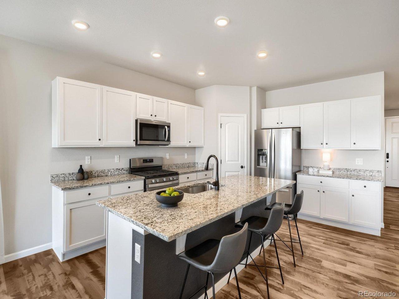 Image 3: Light, airy kitchen with stainless appliances, and upgraded granite.