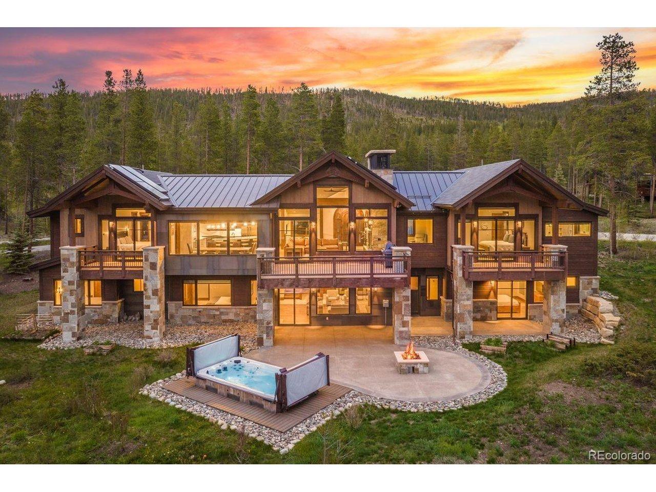 Image 3: Spectacular rear elevation featuring expansive decks, a walkout patio, private hot tub, fire pit, and seamless indoor-outdoor living surrounded by mountain views and serene alpine beauty. Image 3: Spectacular rear elevation featuring expansive decks, a walkout patio, private hot tub, fire pit, and seamless indoor-outdoor living surrounded by mountain views and serene alpine beauty.