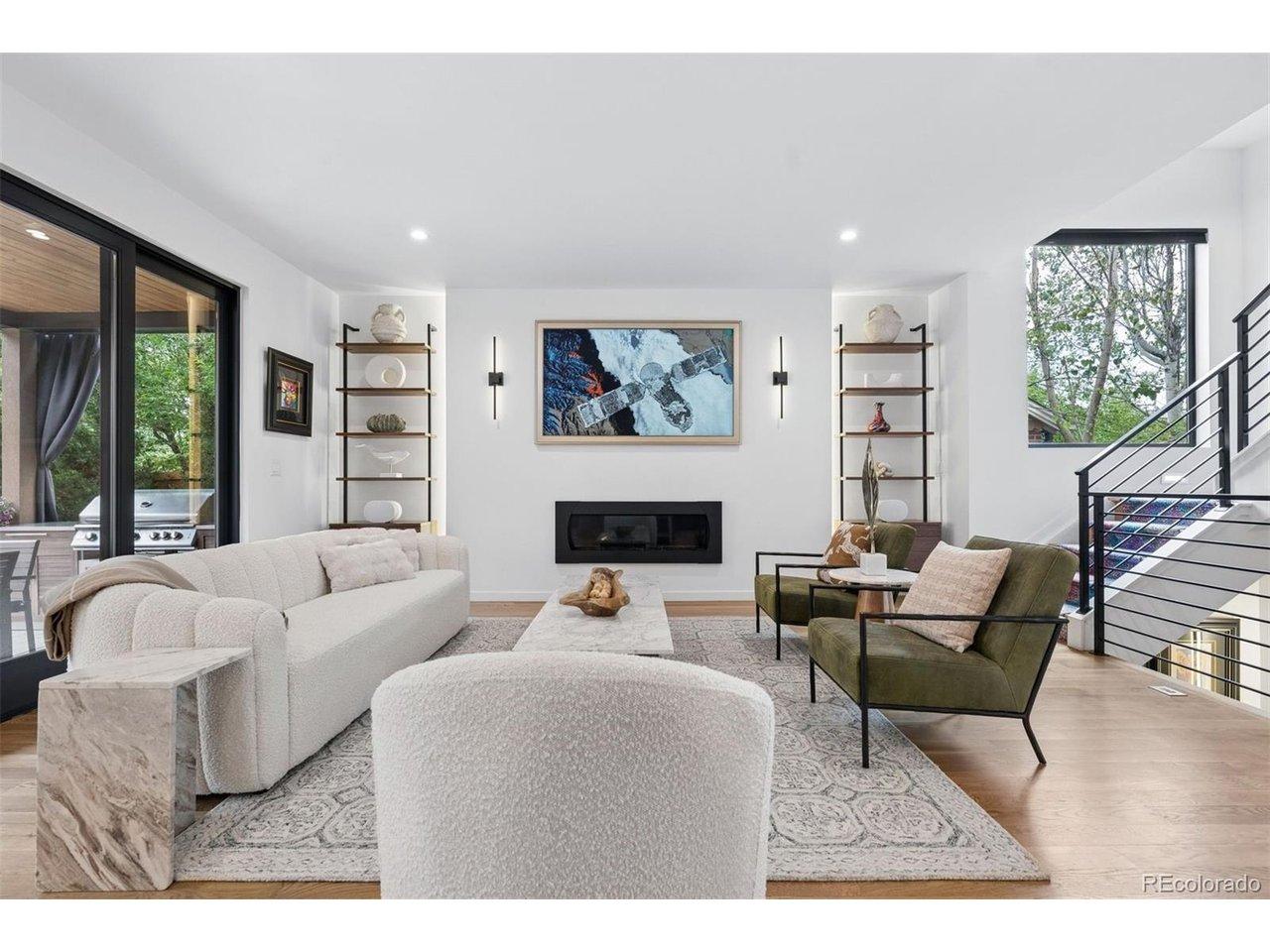 Image 3: Wide open main level living room with gas fireplace, custom sconce lighting, CB2 bookcases (included) and a wall of windows to the backyard Image 3: Wide open main level living room with gas fireplace, custom sconce lighting, CB2 bookcases (included) and a wall of windows to the backyard