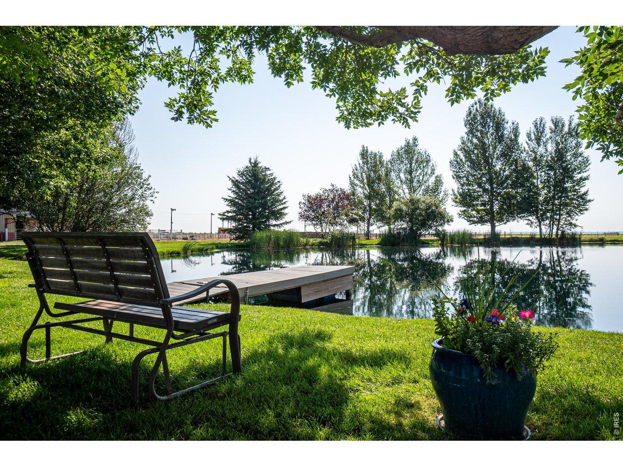 Image 2: The park-like setting includes mature landscaping, sprinkler & drip systems, wood-burning fire-pit, horseshoe pits and large pond with dock Image 2: The park-like setting includes mature landscaping, sprinkler & drip systems, wood-burning fire-pit, horseshoe pits and large pond with dock