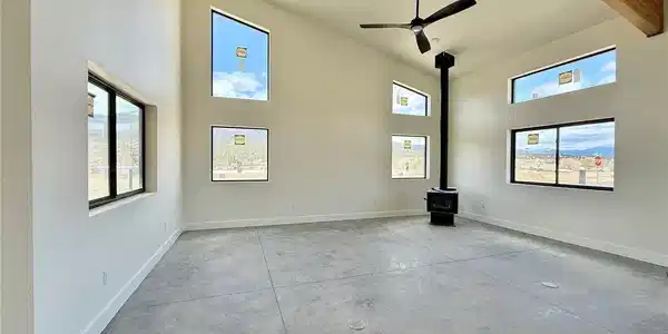 Image 3: Grand living room with tall ceilings, wood beams, and windows.