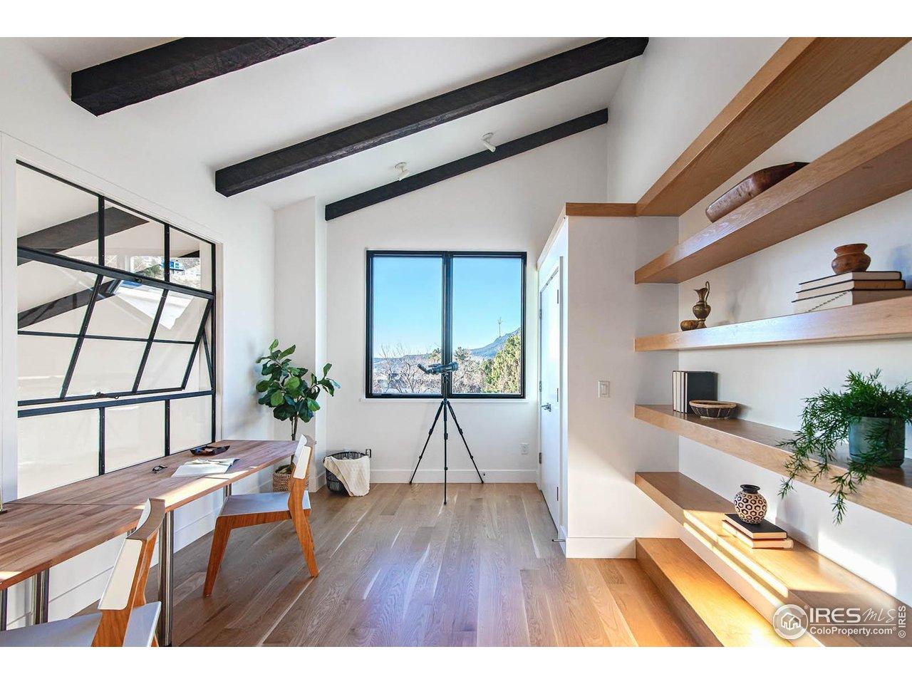 Image 4: View of the Flatirons from handsome office/bedroom with built-in shelves and antique glass window to Great Room below Image 4: View of the Flatirons from handsome office/bedroom with built-in shelves and antique glass window to Great Room below