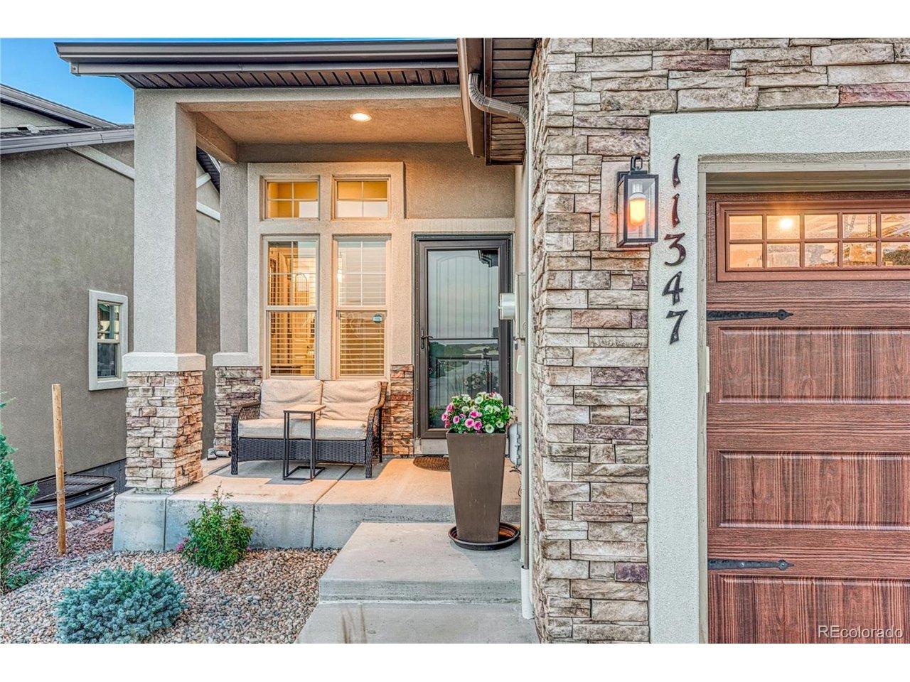 Image 2: A welcoming, south-facing, covered front porch creates the perfect first impression with stone accents and a comfortable space to enjoy the neighborhood surroundings and Pikes Peak views. Image 2: A welcoming, south-facing, covered front porch creates the perfect first impression with stone accents and a comfortable space to enjoy the neighborhood surroundings and Pikes Peak views.
