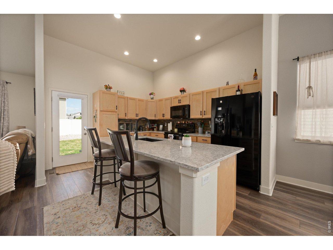 Image 4: Large White & Gray Quartz Island, Natural Cabinetry & Sleek Black Appliances Image 4: Large White & Gray Quartz Island, Natural Cabinetry & Sleek Black Appliances