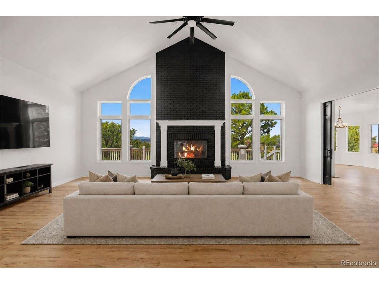 Image 4: Vaulted great room with panoramic mountain views and a striking brick fireplace. *This photo has been virtually staged. Image 4: Vaulted great room with panoramic mountain views and a striking brick fireplace. *This photo has been virtually staged.