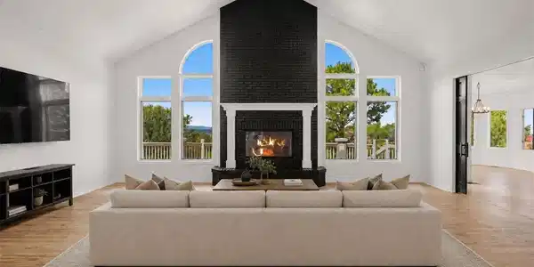 Image 4: Vaulted great room with panoramic mountain views and a striking brick fireplace. *This photo has been virtually staged. Image 4: Vaulted great room with panoramic mountain views and a striking brick fireplace. *This photo has been virtually staged.