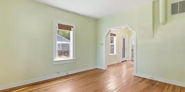 Image 4: Living room with pine hardwood flooring throughout, arched opening, and white trim. Image 4: Living room with pine hardwood flooring throughout, arched opening, and white trim.