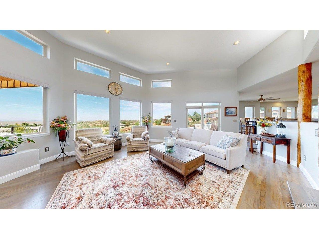 Image 4: The great room is filled with natural light and framed by walls of windows that capture beautiful views of the red rocks, the ravine, Chatfield Reservoir, and even the Denver skyline in the distance. Image 4: The great room is filled with natural light and framed by walls of windows that capture beautiful views of the red rocks, the ravine, Chatfield Reservoir, and even the Denver skyline in the distance.
