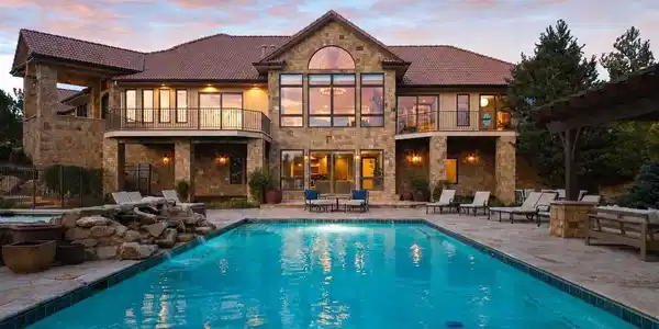 Image 2: Set on 4.95 acres, with an unbeatable location, this exceptional 4 bedroom | 6 bathroom custom residence with a resort-style pool is surrounded by 360-degree views of the entire Front Range, rock formations, rolling pastures, and city lights.