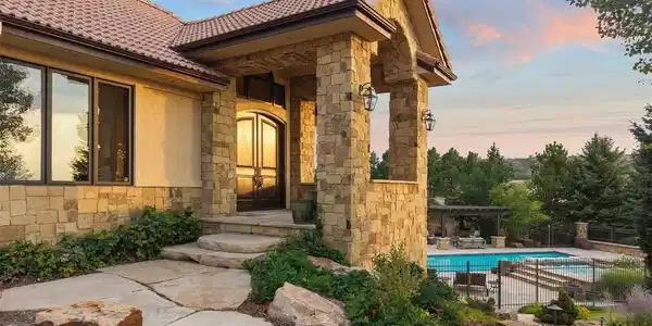 Image 4: Impressive stone entry overlooking the resort-style pool and beautifully landscaped grounds.