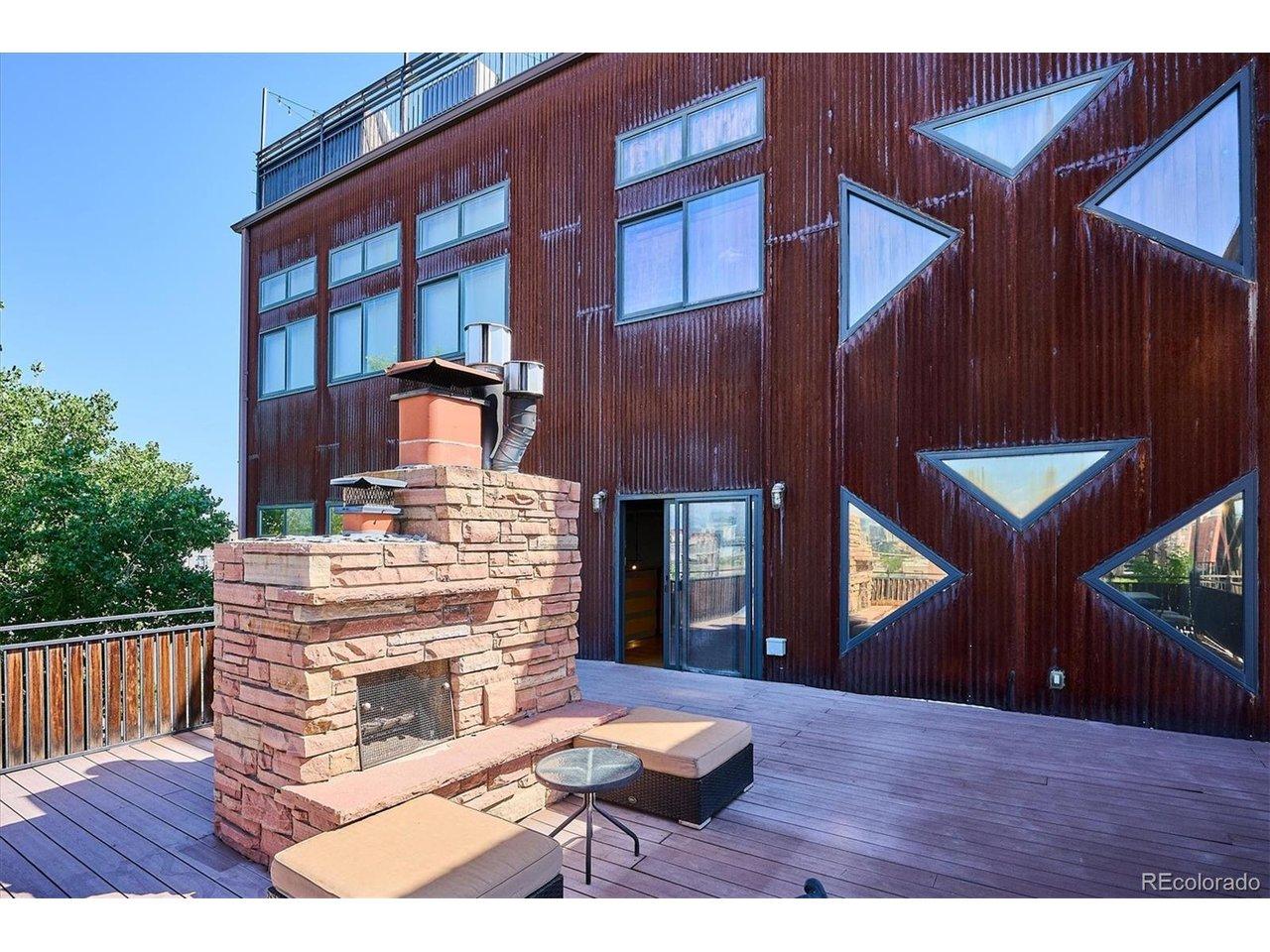 Image 3: Large upper deck with a view of the fireplace and the building Image 3: Large upper deck with a view of the fireplace and the building