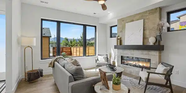 Image 3: Anchored by a sleek electric fireplace with a striking custom tile surround, the sun-filled living room offers the perfect place to relax while enjoying beautiful Flatirons views through expansive south-facing windows. Image 3: Anchored by a sleek electric fireplace with a striking custom tile surround, the sun-filled living room offers the perfect place to relax while enjoying beautiful Flatirons views through expansive south-facing windows.