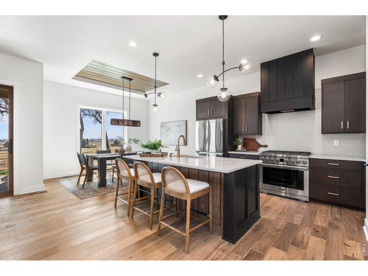 Image 4: The gourmet kitchen boasts a massive quartz island, stainless steel appliances, and elegant light fixtures Image 4: The gourmet kitchen boasts a massive quartz island, stainless steel appliances, and elegant light fixtures