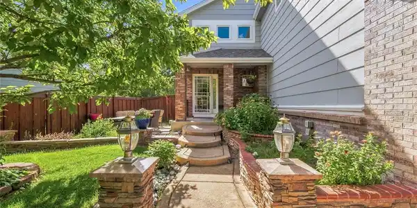 Image 2: A beautifully landscaped front entry creates a warm welcome, with mature greenery and a tucked-away spot to sit and enjoy the outdoors. Image 2: A beautifully landscaped front entry creates a warm welcome, with mature greenery and a tucked-away spot to sit and enjoy the outdoors.
