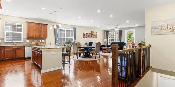 Image 4: An expansive, light-filled open-concept living, dining, and kitchen area featuring rich hardwood floors and seamless flow. Image 4: An expansive, light-filled open-concept living, dining, and kitchen area featuring rich hardwood floors and seamless flow.