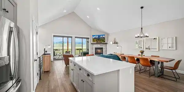 Image 2: Open-concept kitchen and dining area with vaulted ceilings, pendant lighting, and hardwood floors Image 2: Open-concept kitchen and dining area with vaulted ceilings, pendant lighting, and hardwood floors