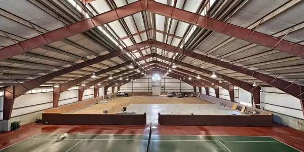 Image 2: Dirt area is approximately 9,050 Sq. ft., the Peak of the building is approximately 30 feet andsidewalls 14 ft. The concrete parking pad is 70 ft. x 56 ft., Tennis Court area is about 109 ft. x 60 ft., 2,525 sq. ft are living quarters Image 2: Dirt area is approximately 9,050 Sq. ft., the Peak of the building is approximately 30 feet andsidewalls 14 ft. The concrete parking pad is 70 ft. x 56 ft., Tennis Court area is about 109 ft. x 60 ft., 2,525 sq. ft are living quarters