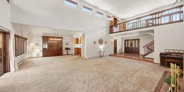 Image 4: Spacious living room featuring soaring ceilings, two ceiling fans, and a cozy fireplace Image 4: Spacious living room featuring soaring ceilings, two ceiling fans, and a cozy fireplace
