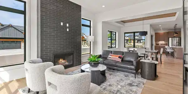 Image 4: Sophisticated living room anchored by a premium fireplace insert and a dramatic ceiling to floor mantel.