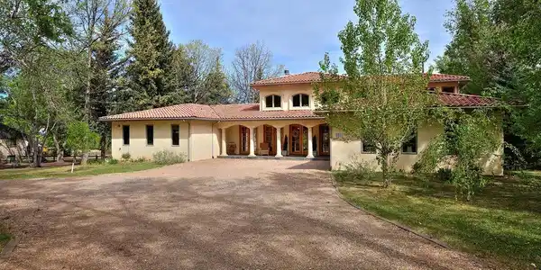 Image 4: Mature trees frame the Tuscan-style exterior Image 4: Mature trees frame the Tuscan-style exterior