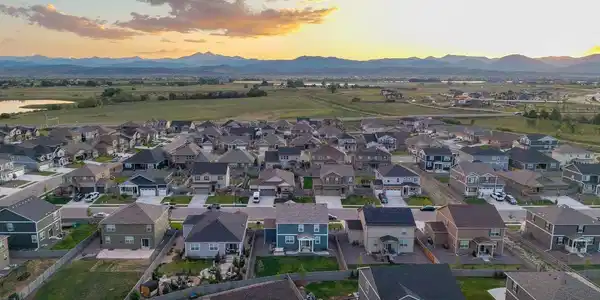 Image 3: Sweeping aerial showcasing the neighborhood's front-range mountain backdrop and nearby reservoir. Image 3: Sweeping aerial showcasing the neighborhood's front-range mountain backdrop and nearby reservoir.