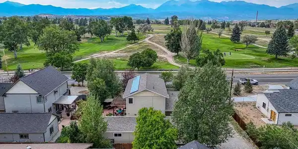 Image 3: Looking over the top of the home. A view of the golf course with the mountain backdrop