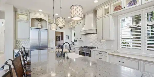 Image 4: The huge quartz island with bar seating serves as the heart of the home