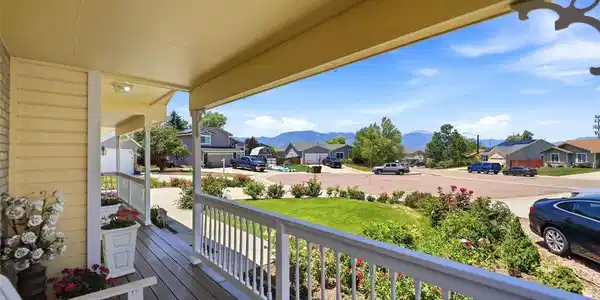 Image 3: Covered front porch with composite wood-finish flooring, white railing, and exterior lighting Image 3: Covered front porch with composite wood-finish flooring, white railing, and exterior lighting