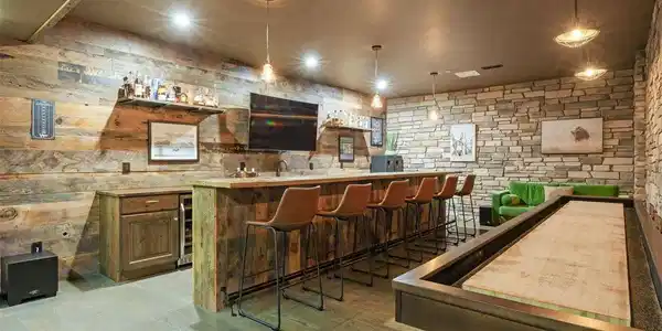 Image 4: If you know the code word a vault door opens to an unexpected private speakeasy. Inside is a 16-foot bar, shuffleboard table, darts, ice maker, fridge, dishwasher & bathroom.