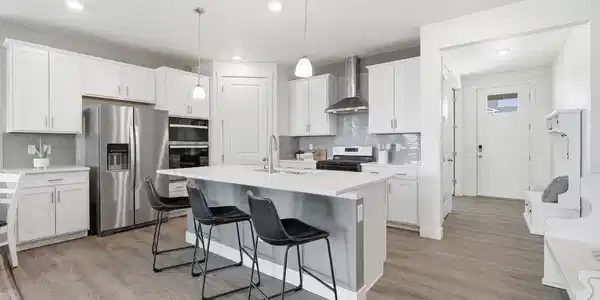 Image 4: The large chef's kitchen features quartz counters with plenty of natural light and prep space.