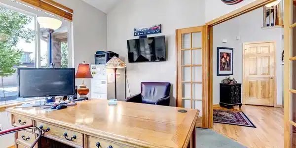 Image 4: Office off of the foyer facing the street with wood trim glass French Doors.