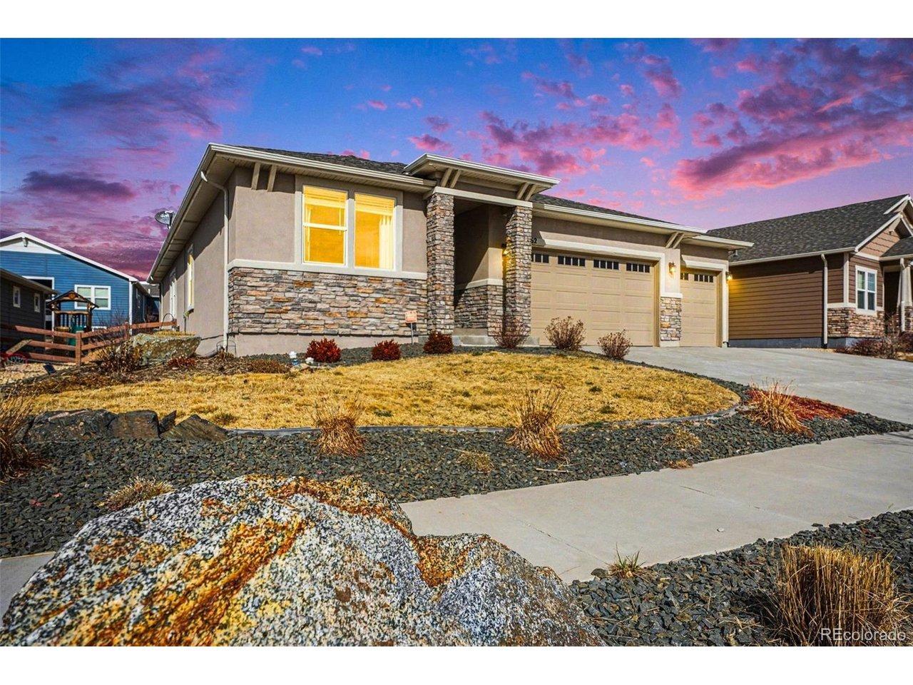 Image 1: The home's front exudes charm with a stucco exterior, a welcoming front patio, and a landscaped yard, all complemented by stunning Front Range mountain views. Image 1: The home's front exudes charm with a stucco exterior, a welcoming front patio, and a landscaped yard, all complemented by stunning Front Range mountain views.