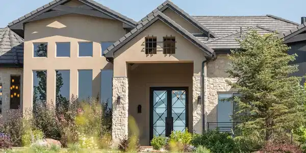 Image 2: A dramatic 10-foot iron front door and handcrafted stone fa ade create an unforgettable first impression. Image 2: A dramatic 10-foot iron front door and handcrafted stone fa ade create an unforgettable first impression.