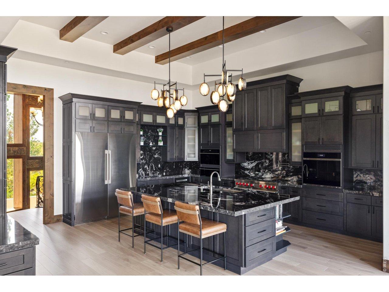 Image 4: Designed for both everyday living and large-scale entertaining, the chef's kitchen features professional-grade appliances, abundant custom cabinetry, and an oversized gathering island. Image 4: Designed for both everyday living and large-scale entertaining, the chef's kitchen features professional-grade appliances, abundant custom cabinetry, and an oversized gathering island.