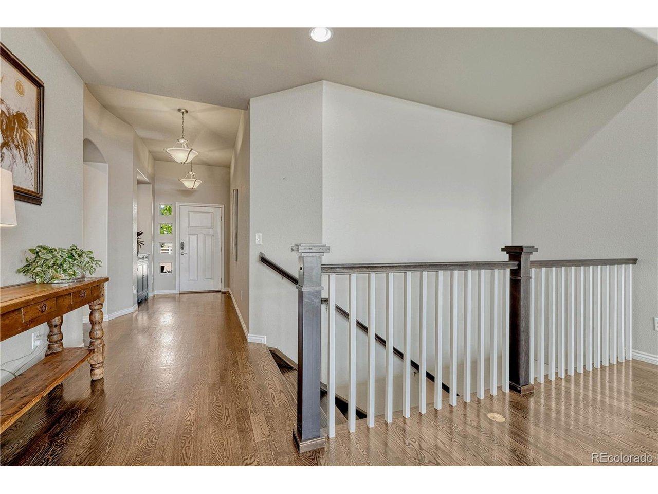 Image 3: Stepping inside, the bright foyer showcases gorgeous oak hardwood floors and an open-concept design that leads to a classic dark-wood staircase Image 3: Stepping inside, the bright foyer showcases gorgeous oak hardwood floors and an open-concept design that leads to a classic dark-wood staircase