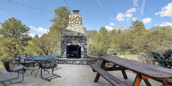 Image 4: Entertaining space with wood burning fireplace and views of the nearby peaks. Image 4: Entertaining space with wood burning fireplace and views of the nearby peaks.