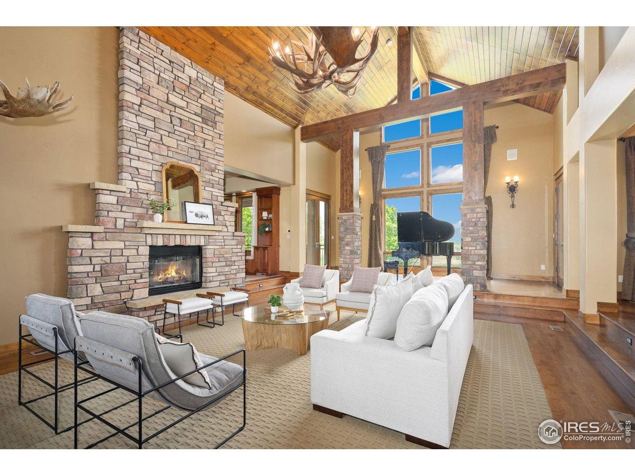 Image 4: Grand living room with stacked stone fireplace and beamed ceiling
