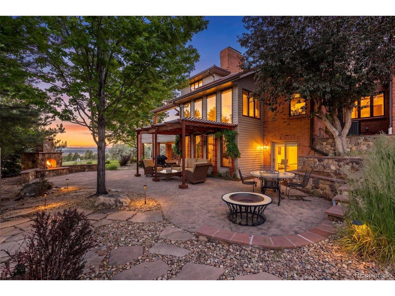 Image 2: The backyard is designed for outdoor living, with a stamped concrete patio, pergola-covered seating area, stone fireplace, mature landscaping, and mountain views beyond the trees. Image 2: The backyard is designed for outdoor living, with a stamped concrete patio, pergola-covered seating area, stone fireplace, mature landscaping, and mountain views beyond the trees.