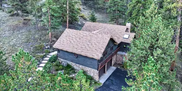 Image 2: An elevated perspective showcases the home s private, tree-filled setting and classic mountain architecture. Image 2: An elevated perspective showcases the home s private, tree-filled setting and classic mountain architecture.