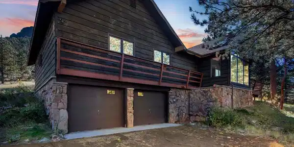 Image 3: The attached two-car garage provides convenient access, while the stone accents and wraparound deck enhance the home s distinctive mountain character. Image 3: The attached two-car garage provides convenient access, while the stone accents and wraparound deck enhance the home s distinctive mountain character.