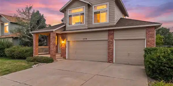 Image 2: Angled twilight view showcasing the brick accents, warm exterior lighting, covered front porch, and impressive three-car garage. Image 2: Angled twilight view showcasing the brick accents, warm exterior lighting, covered front porch, and impressive three-car garage.