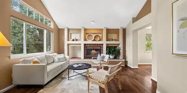 Image 4: Expansive windows fill the living room with natural light, while the vaulted ceiling and fireplace create an open and inviting atmosphere. Image 4: Expansive windows fill the living room with natural light, while the vaulted ceiling and fireplace create an open and inviting atmosphere.